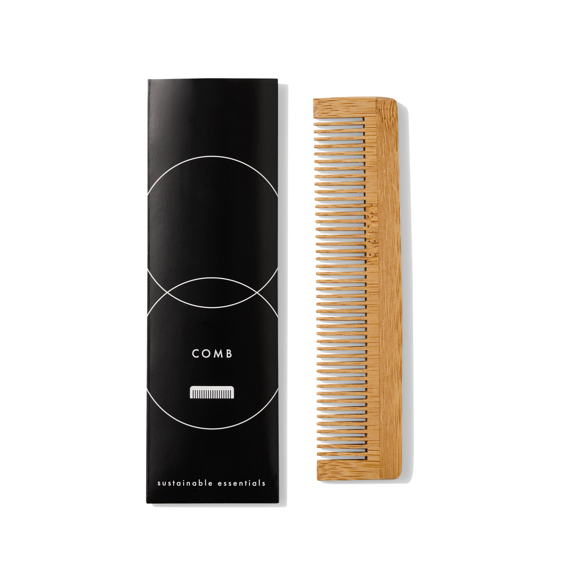 A wooden hair comb next to its black packaging box labeled "comb sustainable essentials."